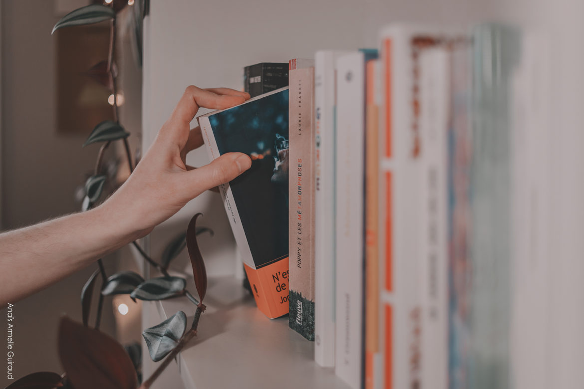 Bibliothèque et livre par Anais Armelle Guiraud Personne prenant un livre dans une bibliothèque